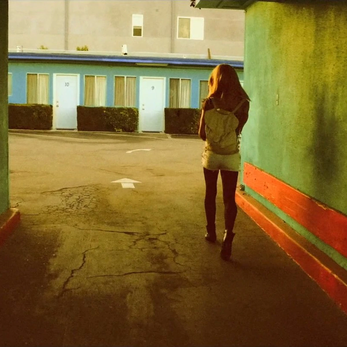 Tangerine: a figure at the end of a green alley in low orange sun
